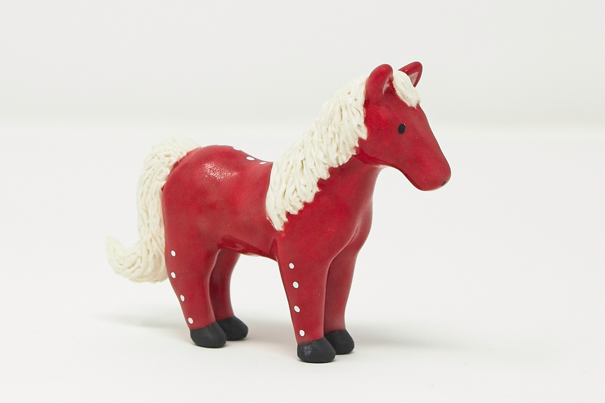 A miniature red ceramic horse.